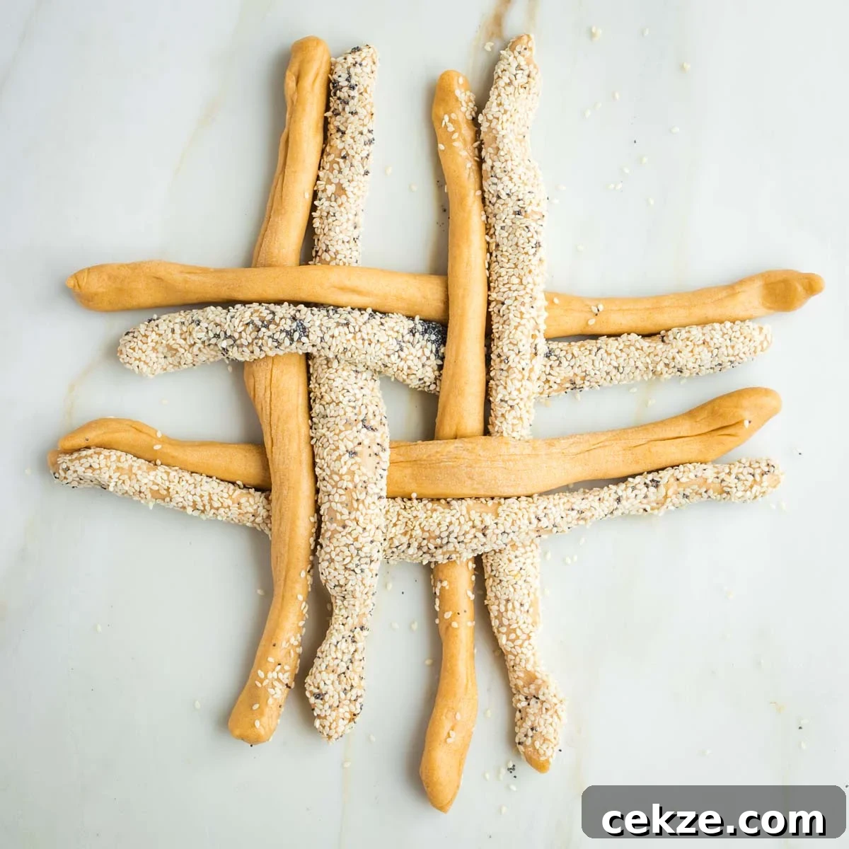 Sweet Round Challah Recipe: Soft, Shiny Braided Dinner Bread 25 Grid of challah dough ropes, some with seeds, some without.