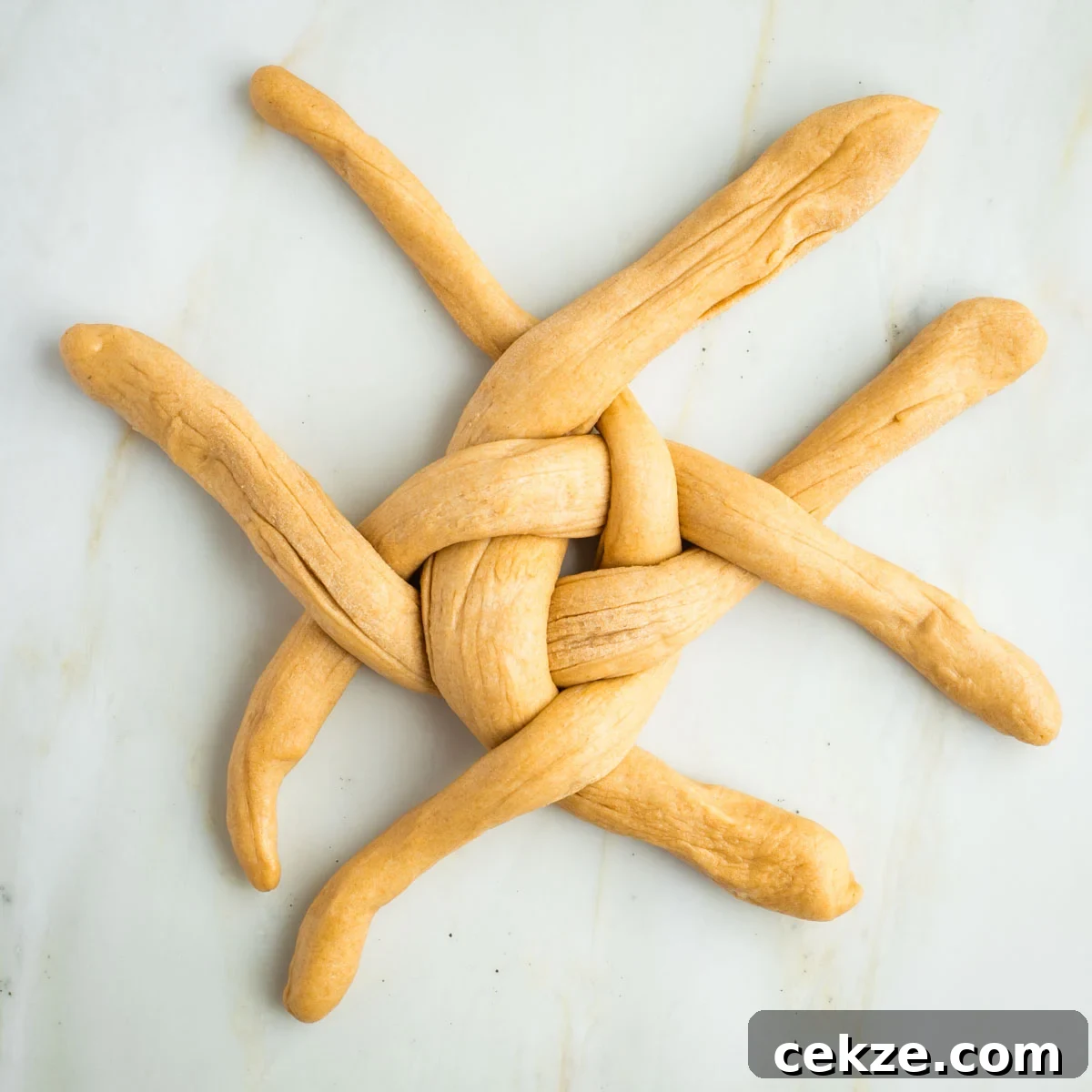 Sweet Round Challah Recipe: Soft, Shiny Braided Dinner Bread 29 Long ropes of dough alternating over and under in a cross pattern.