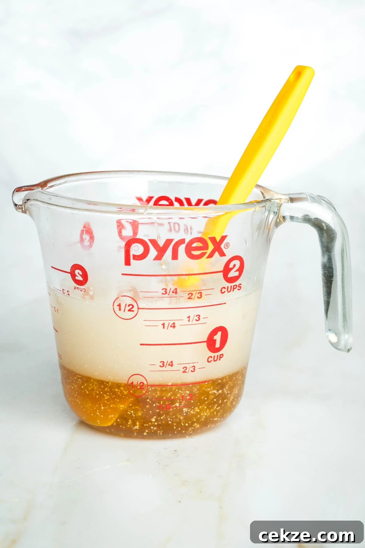 Sweet Round Challah Recipe: Soft, Shiny Braided Dinner Bread 5 Side view of a glass cup with water, honey and yeast proofing.