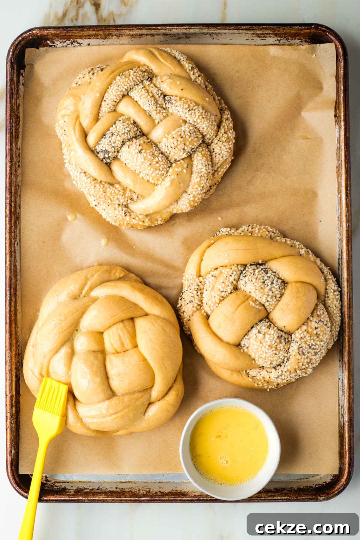 Sweet Round Challah Recipe: Soft, Shiny Braided Dinner Bread 33 Brushing egg wash on braided round loaves of challah bread.