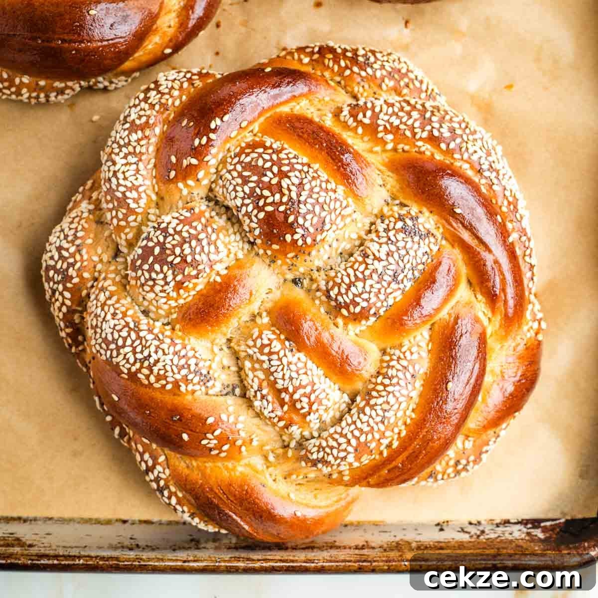 Sweet Round Challah Recipe: Soft, Shiny Braided Dinner Bread 36 Golden brown, partially seeded, braided loaf of round challah.