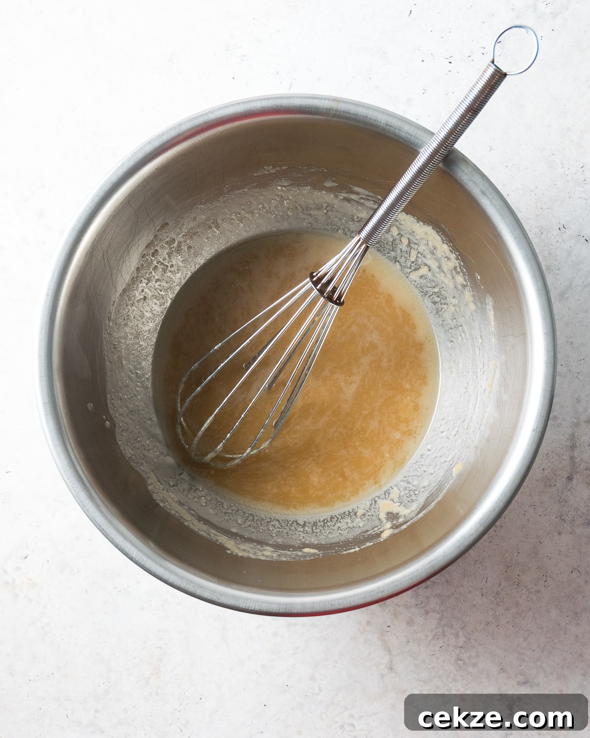 Melted butter in a large metal bowl.