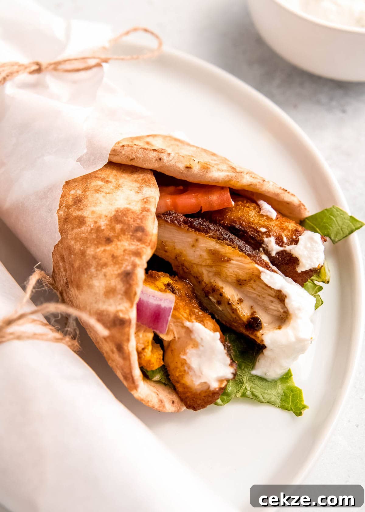 close up image of chicken shawarma on white plate 