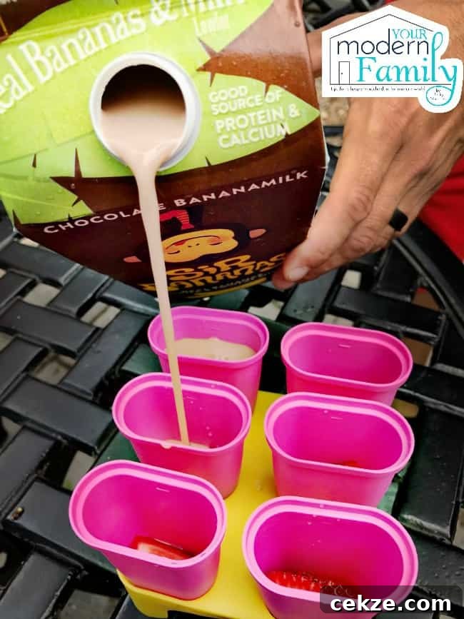 A person pouring banana milk into freezer pop molds.