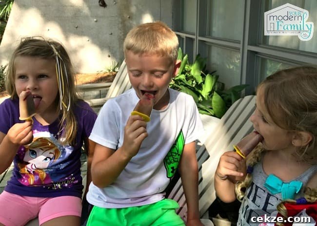 A little boy and two girls eating Chocolate covered strawberry banana freezer pops.