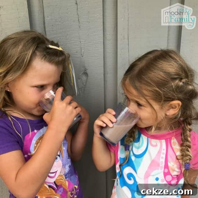 Two girls drinking banana chocolate milk.