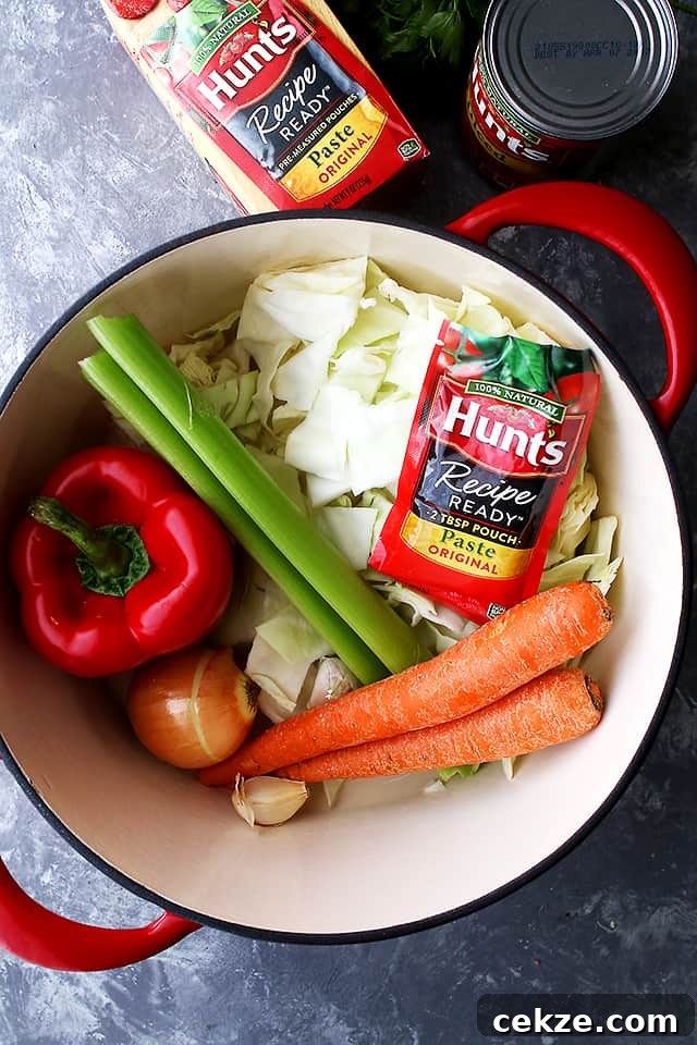 This quick and easy cabbage soup is made with a flavorful tomato broth loaded with tender rice and lots of veggies. Ingredients for cabbage soup with rice in a soup pot.