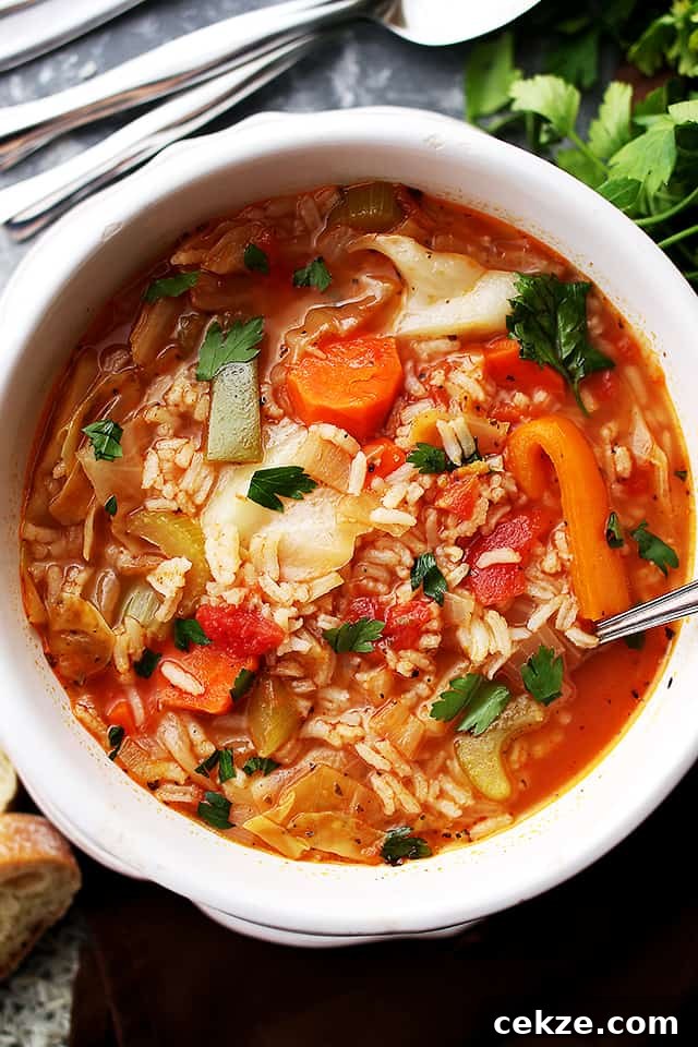 This quick and easy cabbage soup is made with a flavorful tomato broth loaded with tender rice and lots of veggies. Cabbage soup with rice served in a bowl.