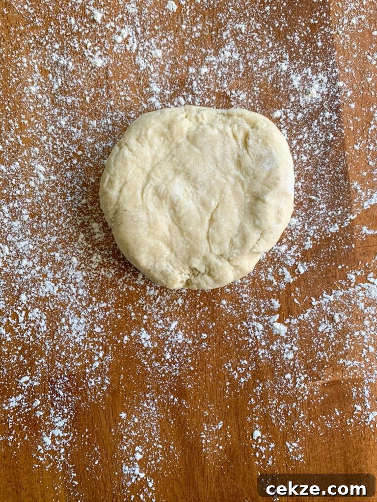 Flaky All-Butter Pie Crust Recipe for Perfect Homemade Pies 11 A disc of pie dough on a flour covered wooden table.