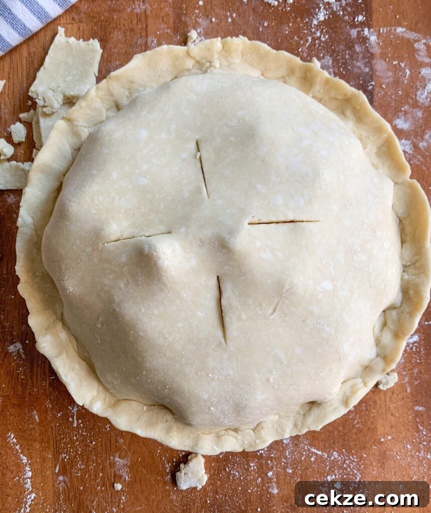 Flaky All-Butter Pie Crust Recipe for Perfect Homemade Pies 7 An image of a raw pie, with a criss cross design cut in the top.