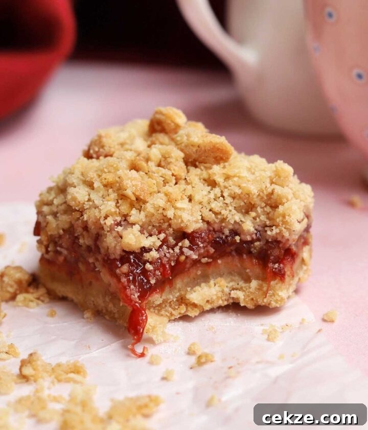 strawberry crisp bars with bite showing gooey strawberry filling