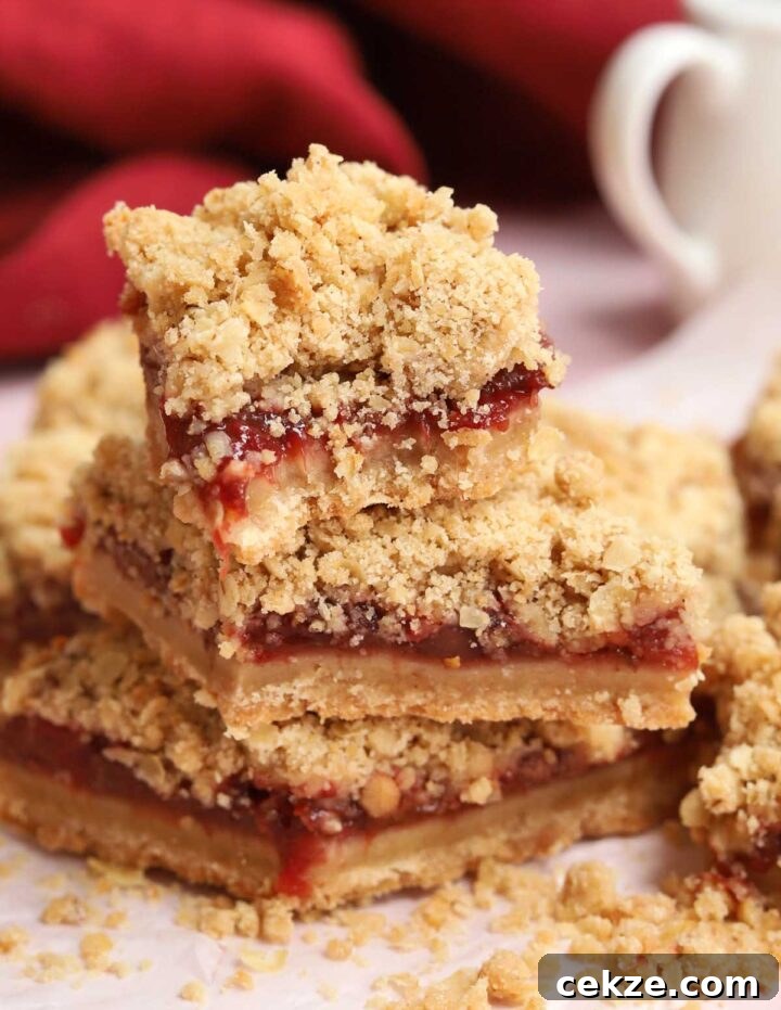 stack of strawberry crisp bars parchment paper with bite out of top bar