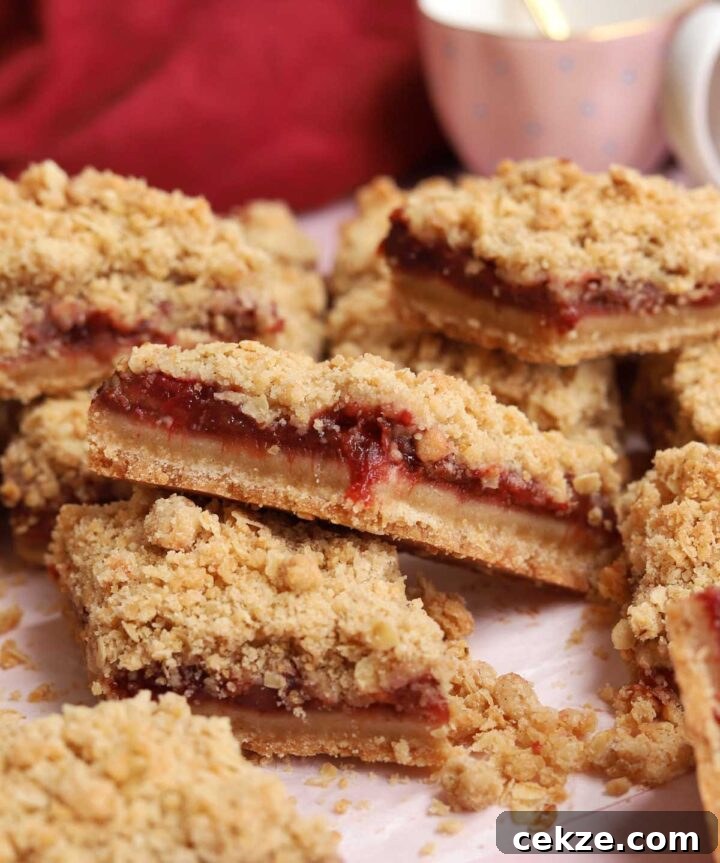 sliced strawberry crisp bars piled up on parchment paper