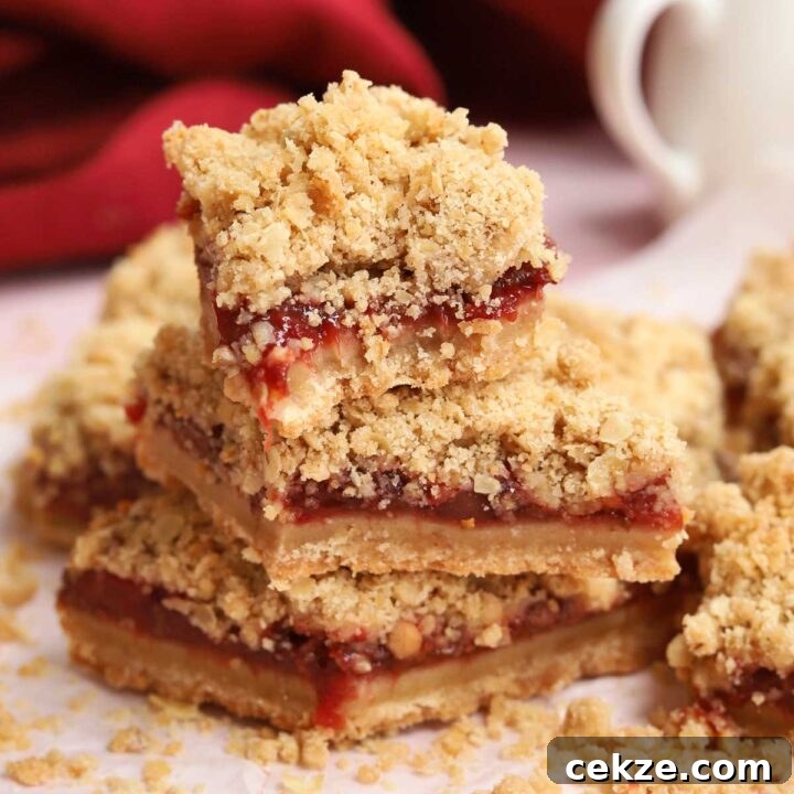 stack of strawberry crisp bars parchment paper with bite out of top bar
