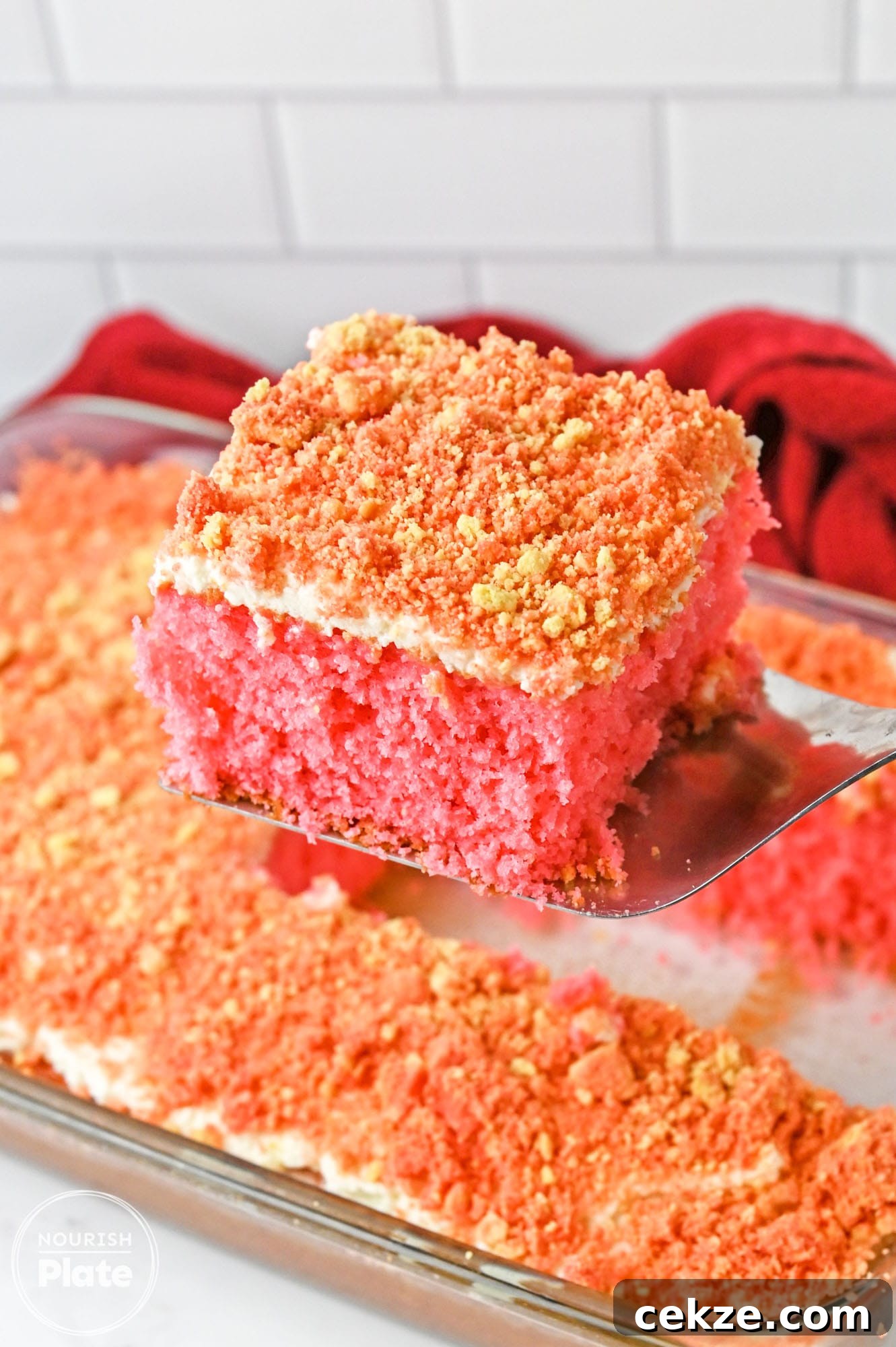 Taking a slice of strawberry crunch cake from the cake pan