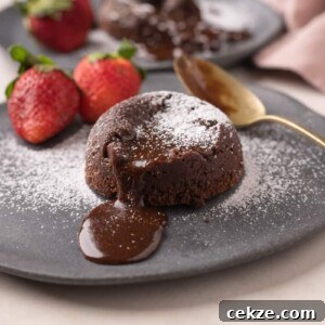 Picture of chocolate oozing out of mocha lava cake with strawberries on the side