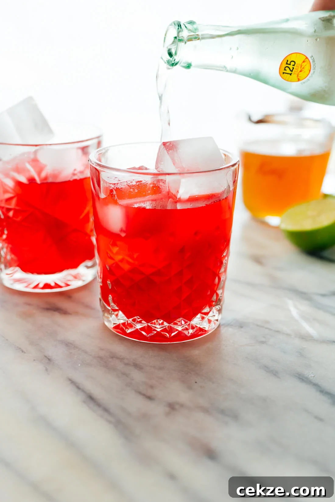 Hibiscus Cooler Mocktail Recipe: Refreshing Floral Summer Drink 4 pouring sparkling water into summer mocktail