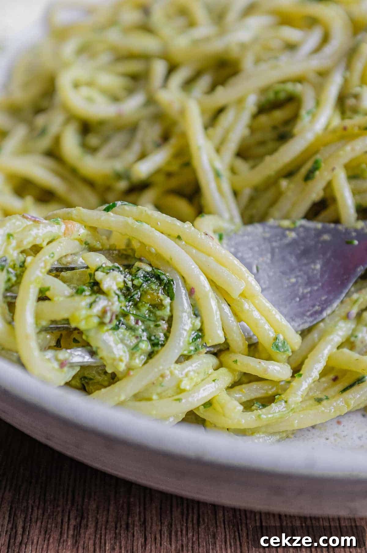 Pasta with Pistachio Pesto | cookeatworld.com A fork wraps around spaghetti with Pistachio Pesto in a large bowl