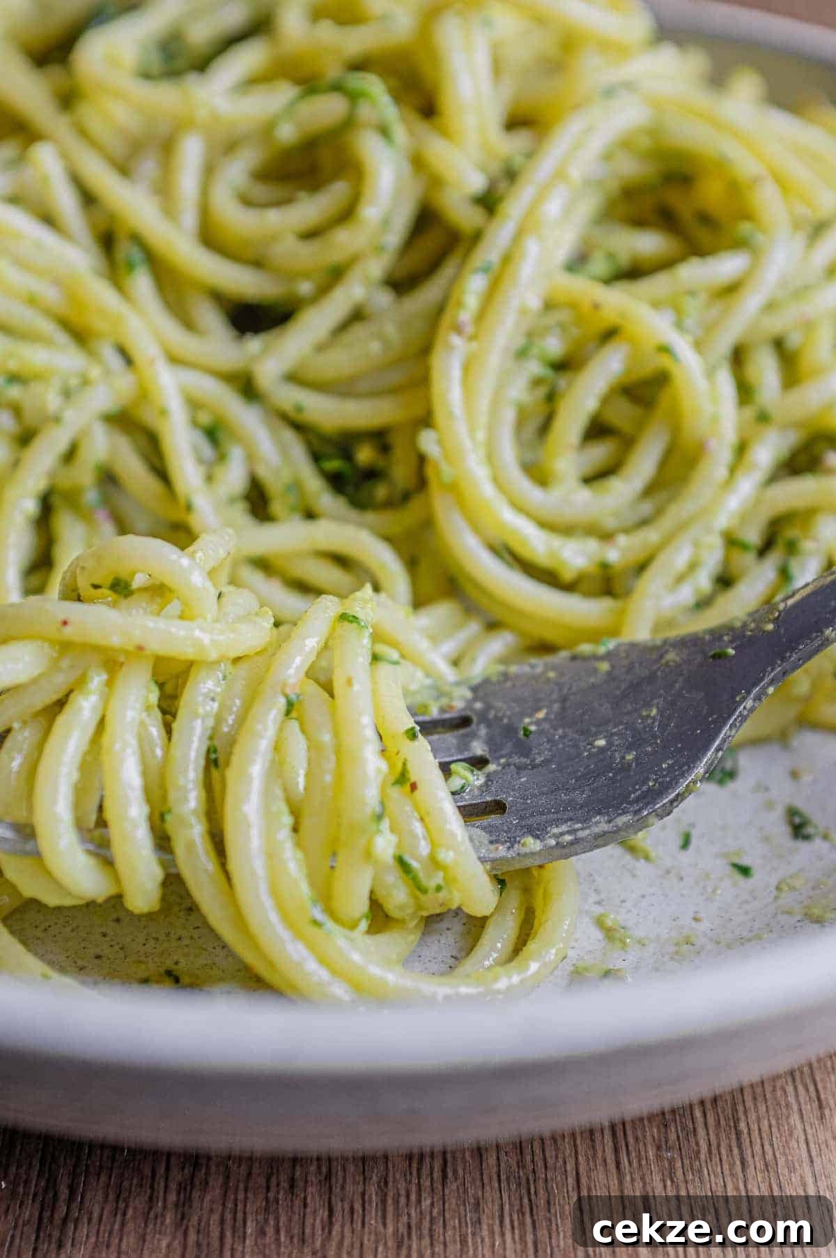 Pasta with Pistachio Pesto | cookeatworld.com A fork wraps around spaghetti with Pistachio Pesto in a large bowl
