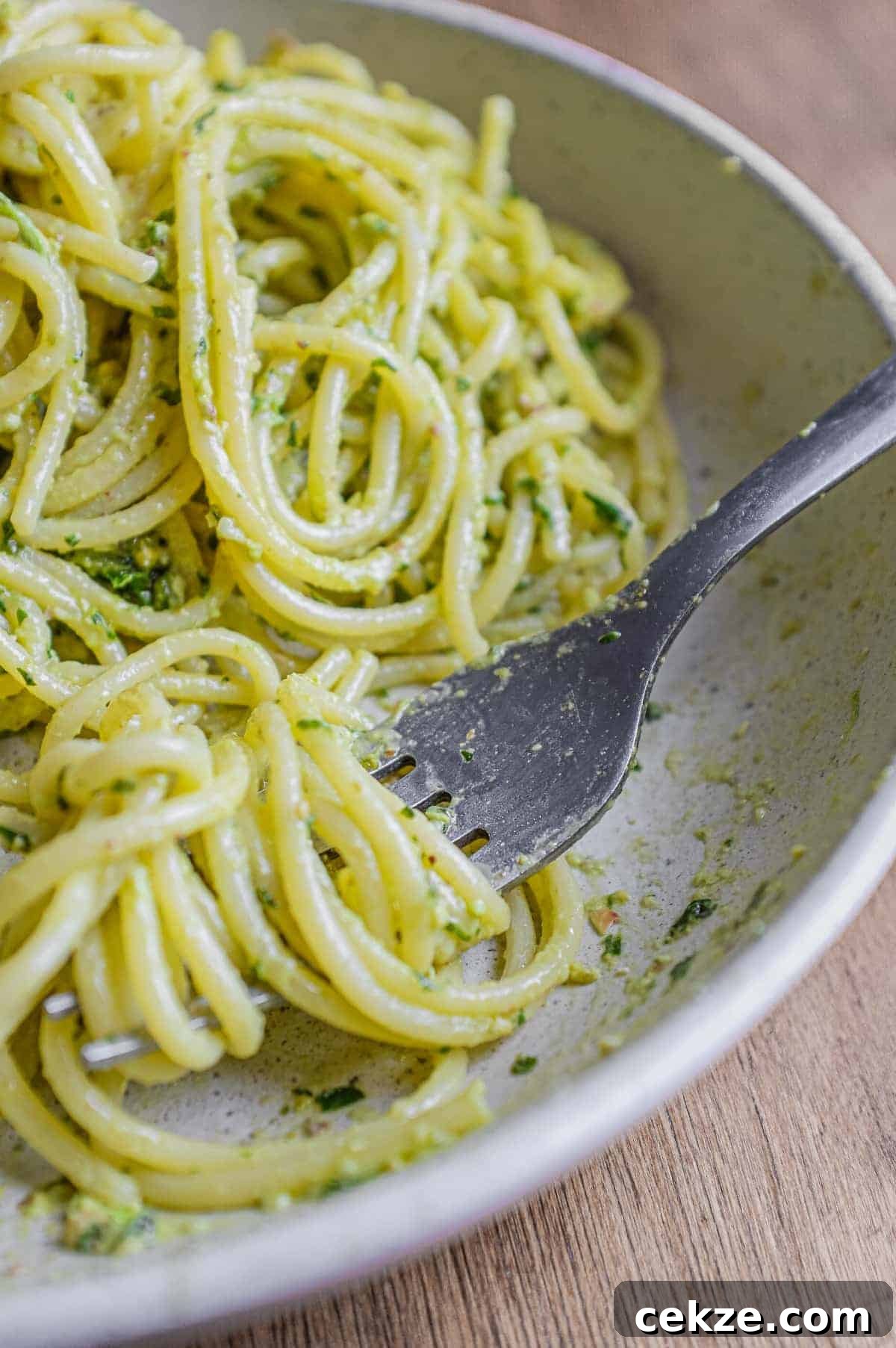 Pasta with Pistachio Pesto | cookeatworld.com A fork wraps around spaghetti with Pistachio Pesto in a large bowl