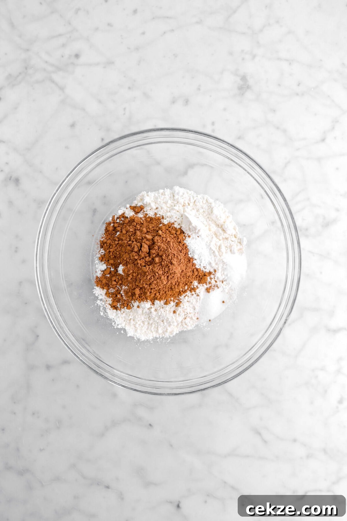 flour, cocoa powder, salt, baking soda, and baking powder in glass bowl.