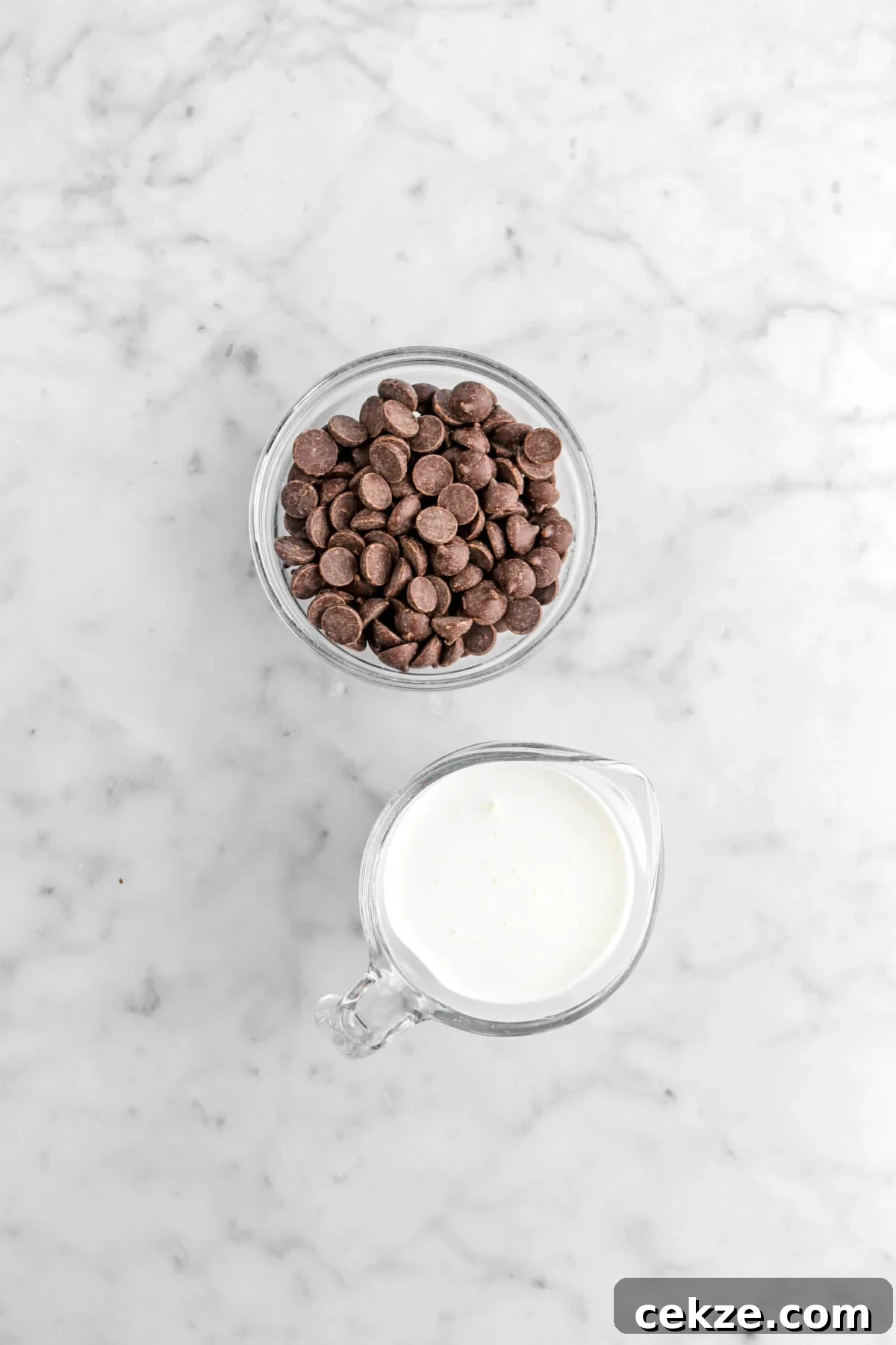 Chocolate chips and cream on marble surface.