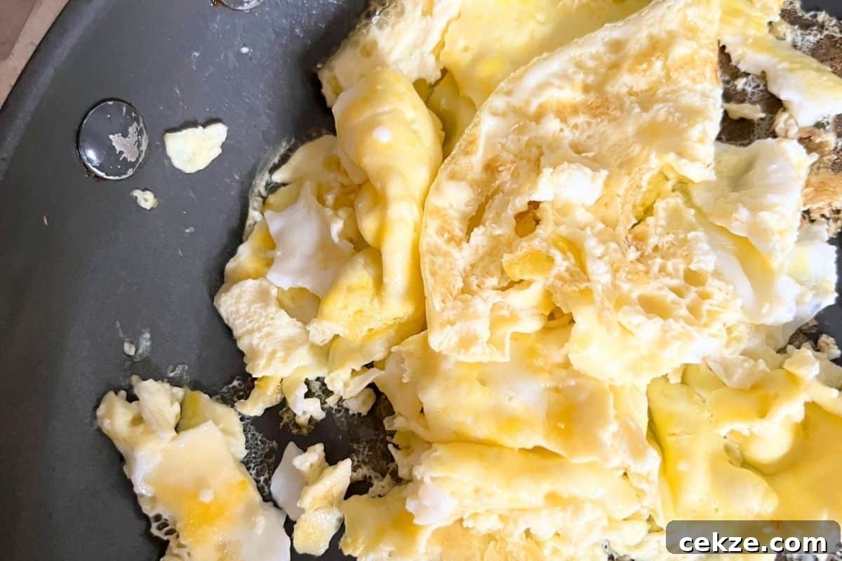Crispy Air Fryer Breakfast Pizza Recipe for Quick Mornings 3 Scrambled eggs in frying pan.