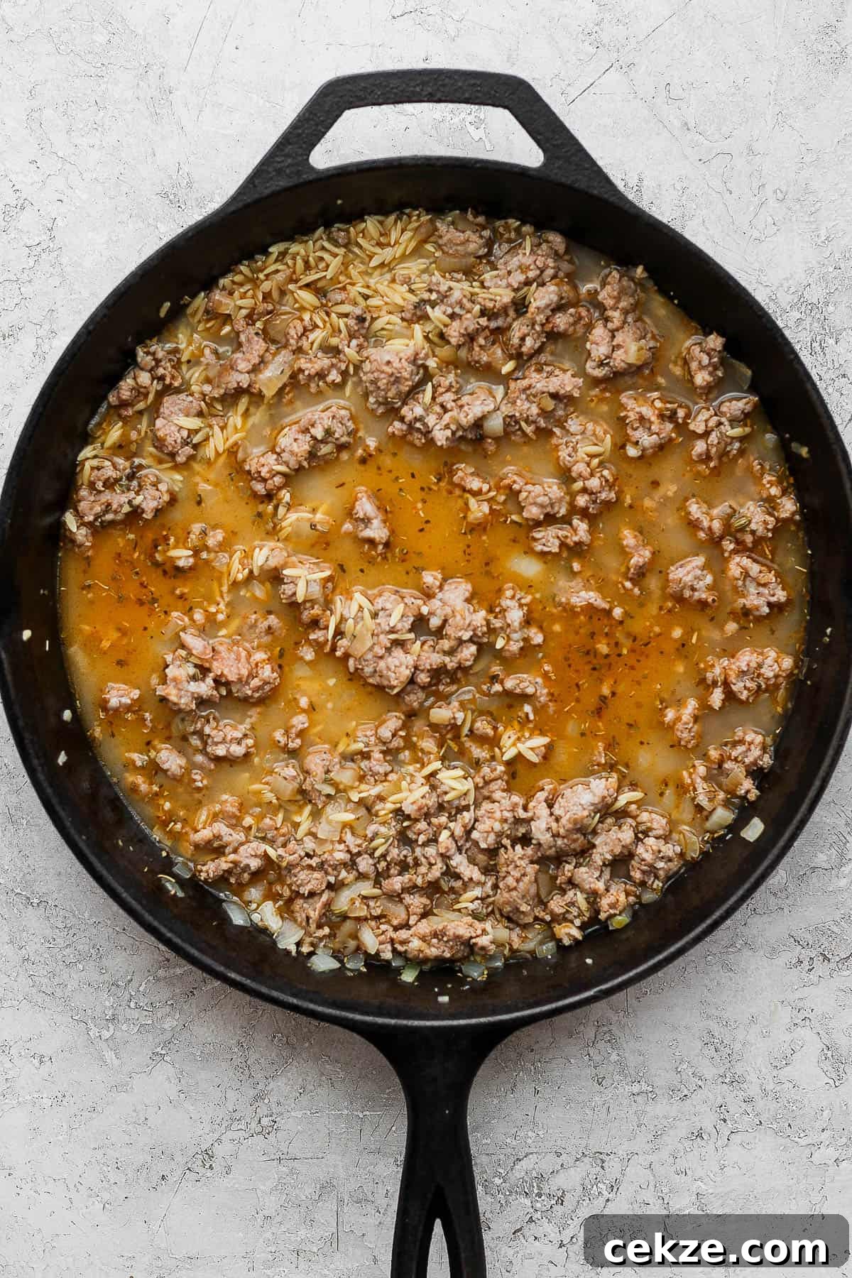 The chicken broth and orzo mixed in to cook.