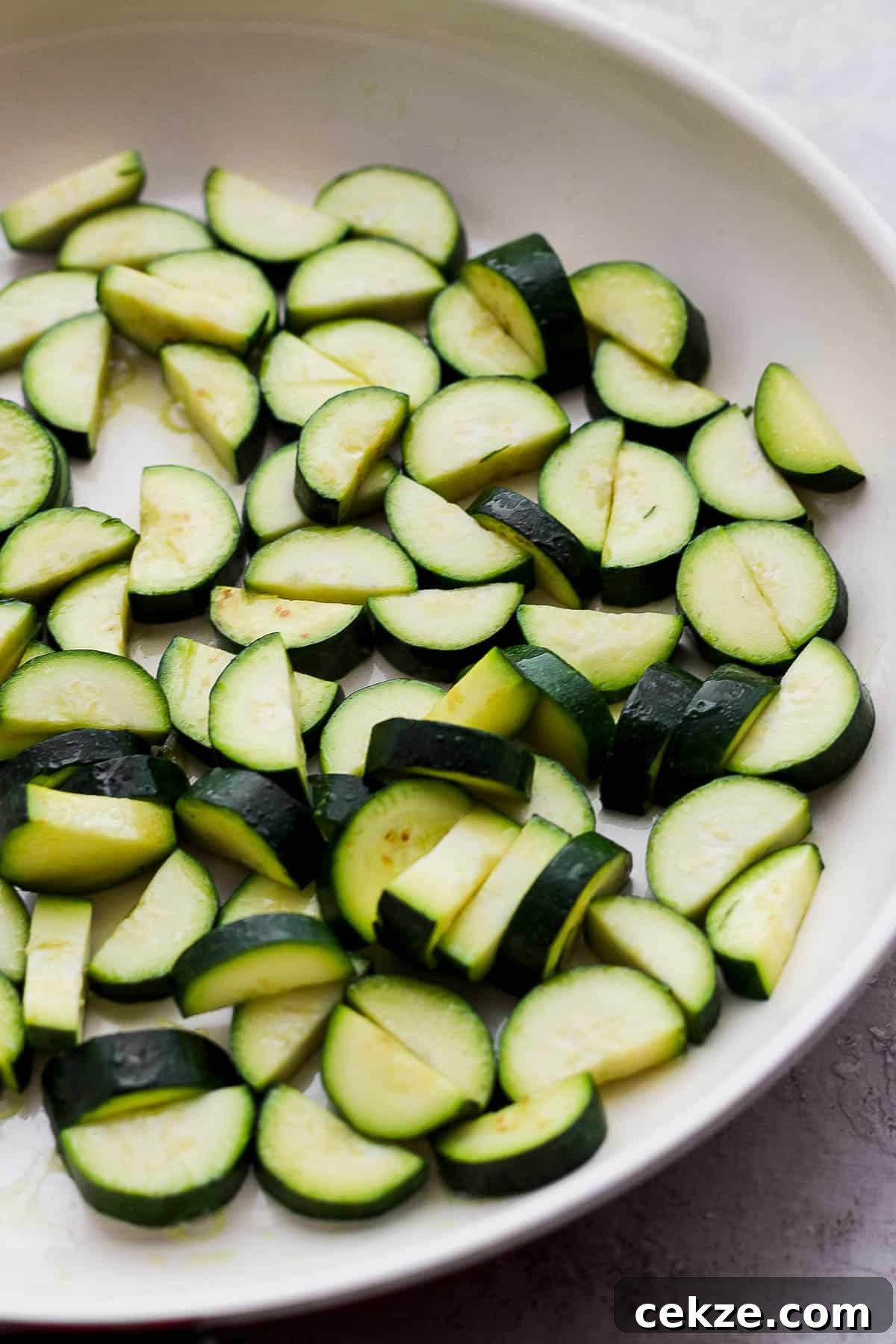 Fresh zucchini sautéing in a separate skillet.