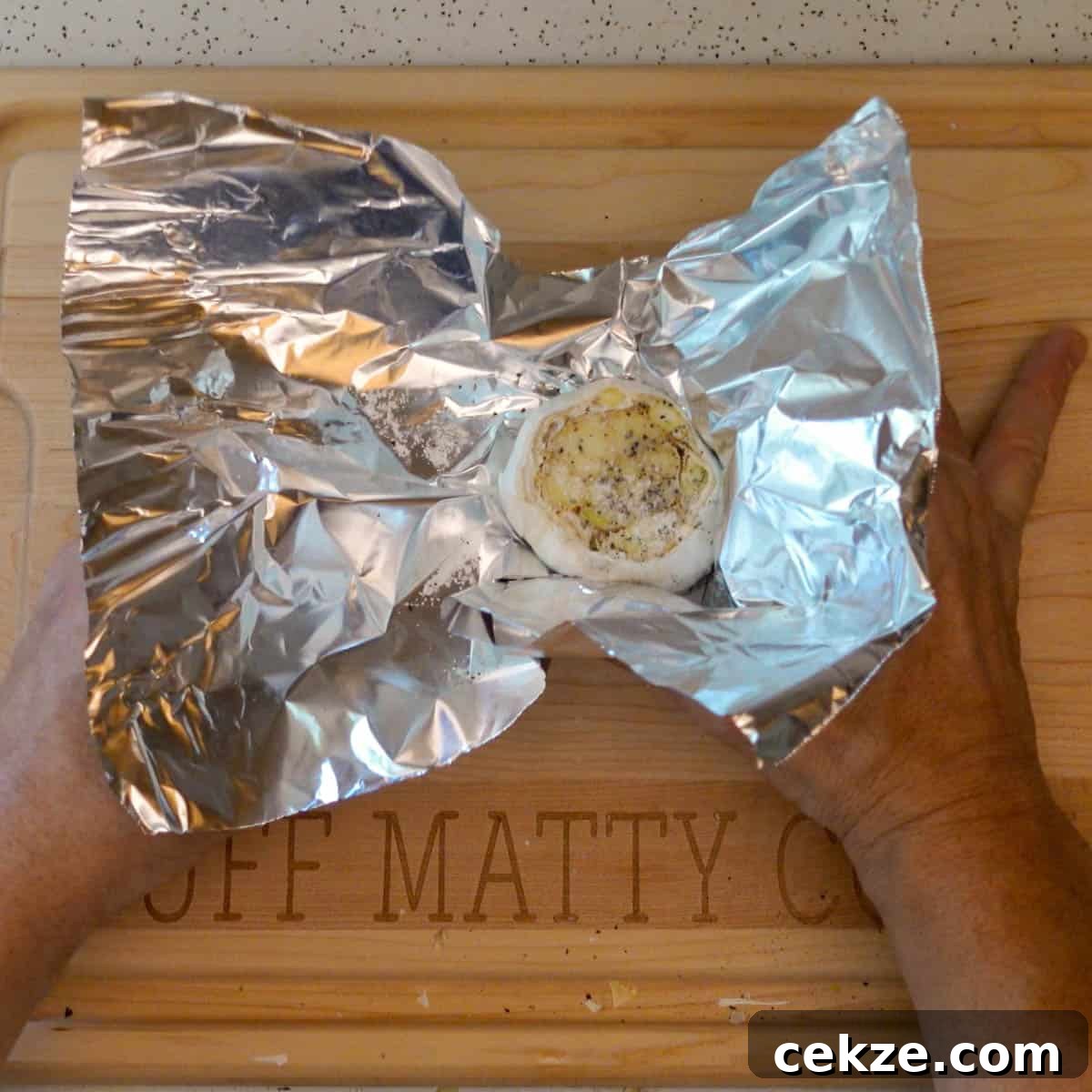 roasted garlic getting wrapped in foil for roasting