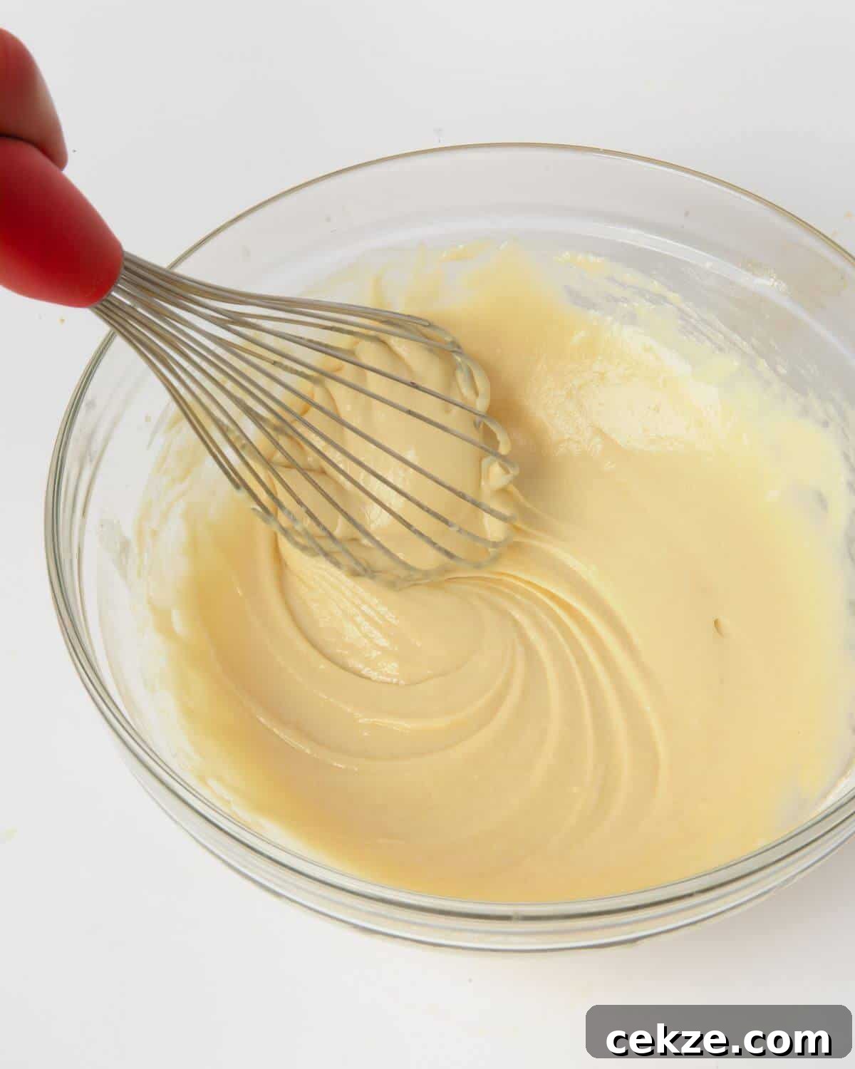 funnel cake batter in mixing bowl with whisk