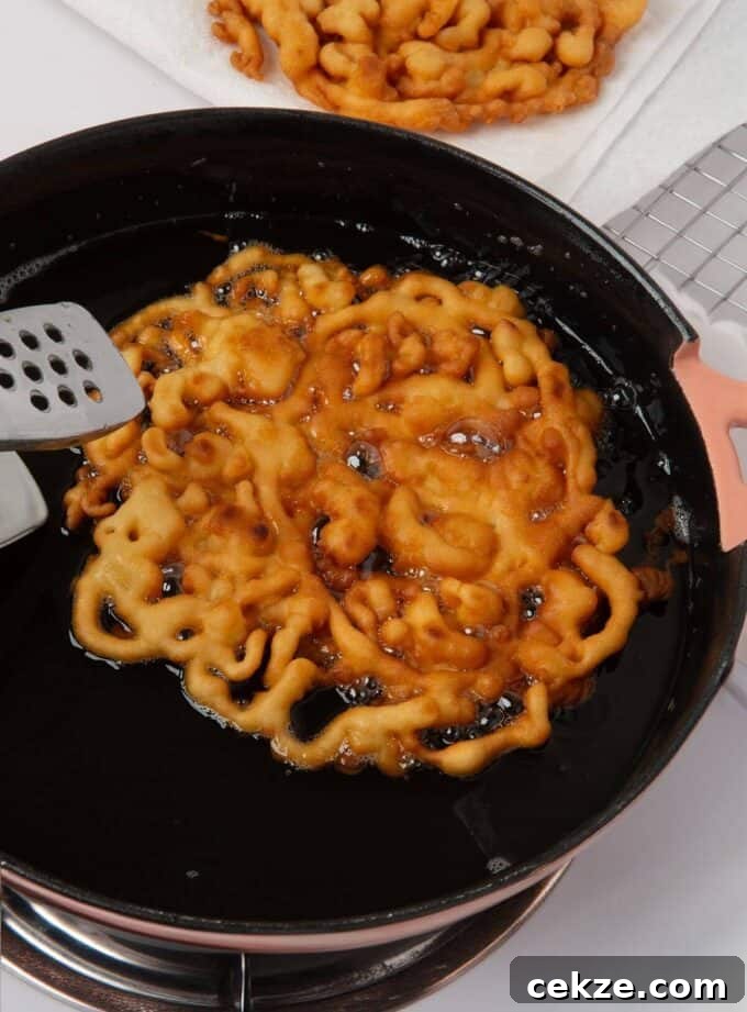 funnel cake frying in oil in skillet