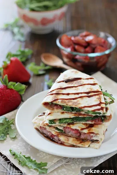 Several Brie Quesadillas stacked on a white plate.