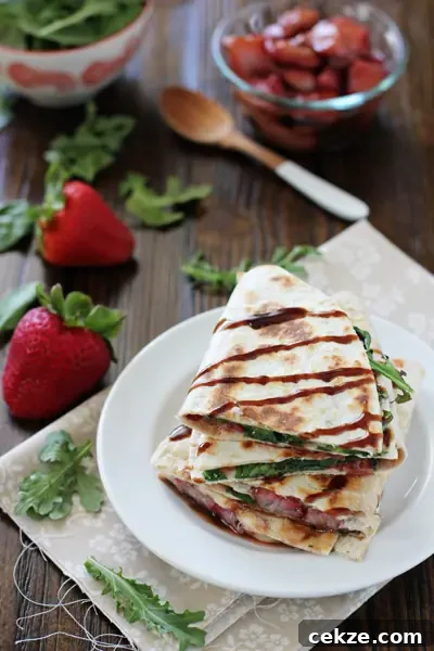Cut triangles of Brie Quesadillas stacked on a plate.