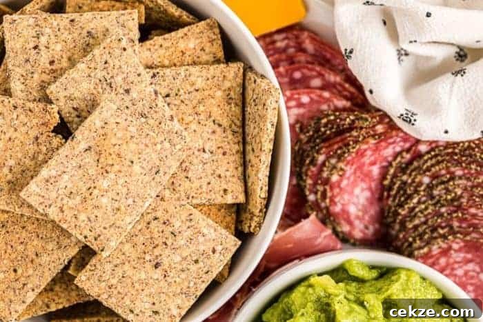keto crackers in a bowl next to meats and cheeses