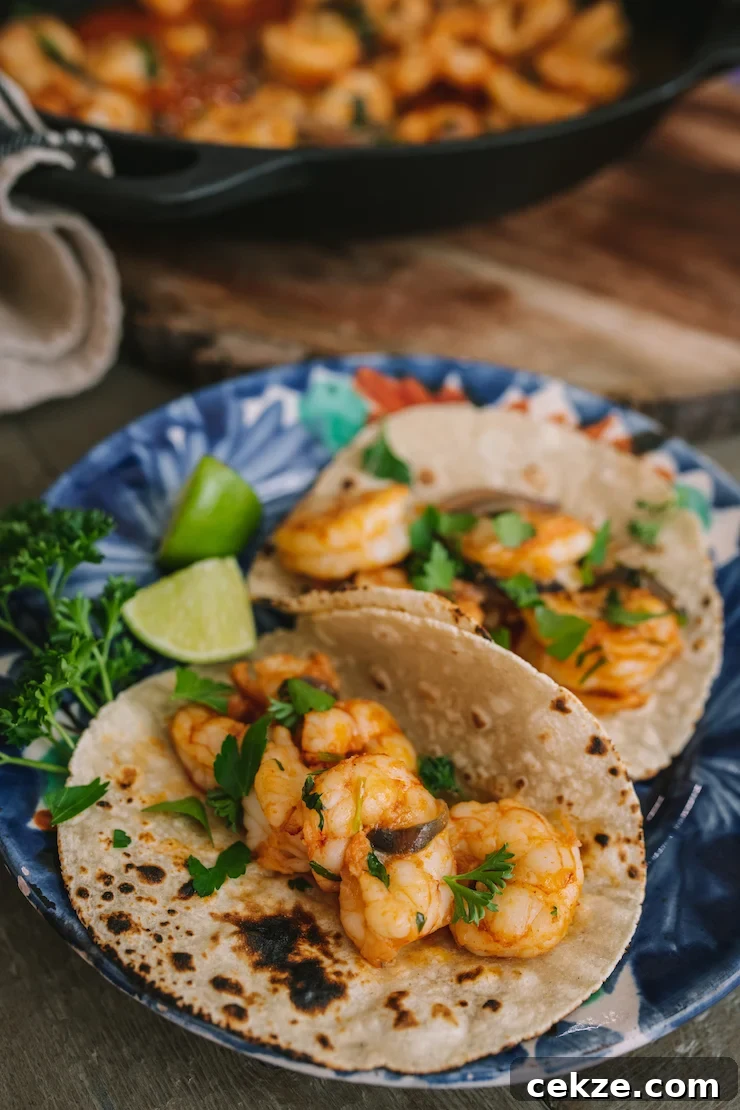 a plate with two tacos filled with Mexican-Style Garlic Shrimp.