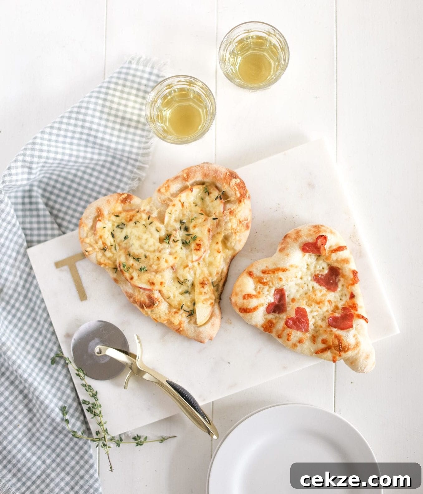 two heart shaped apple cheddar thyme pizzas on a tray
