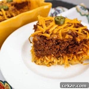 Slice of chili spaghetti pie on a white plate