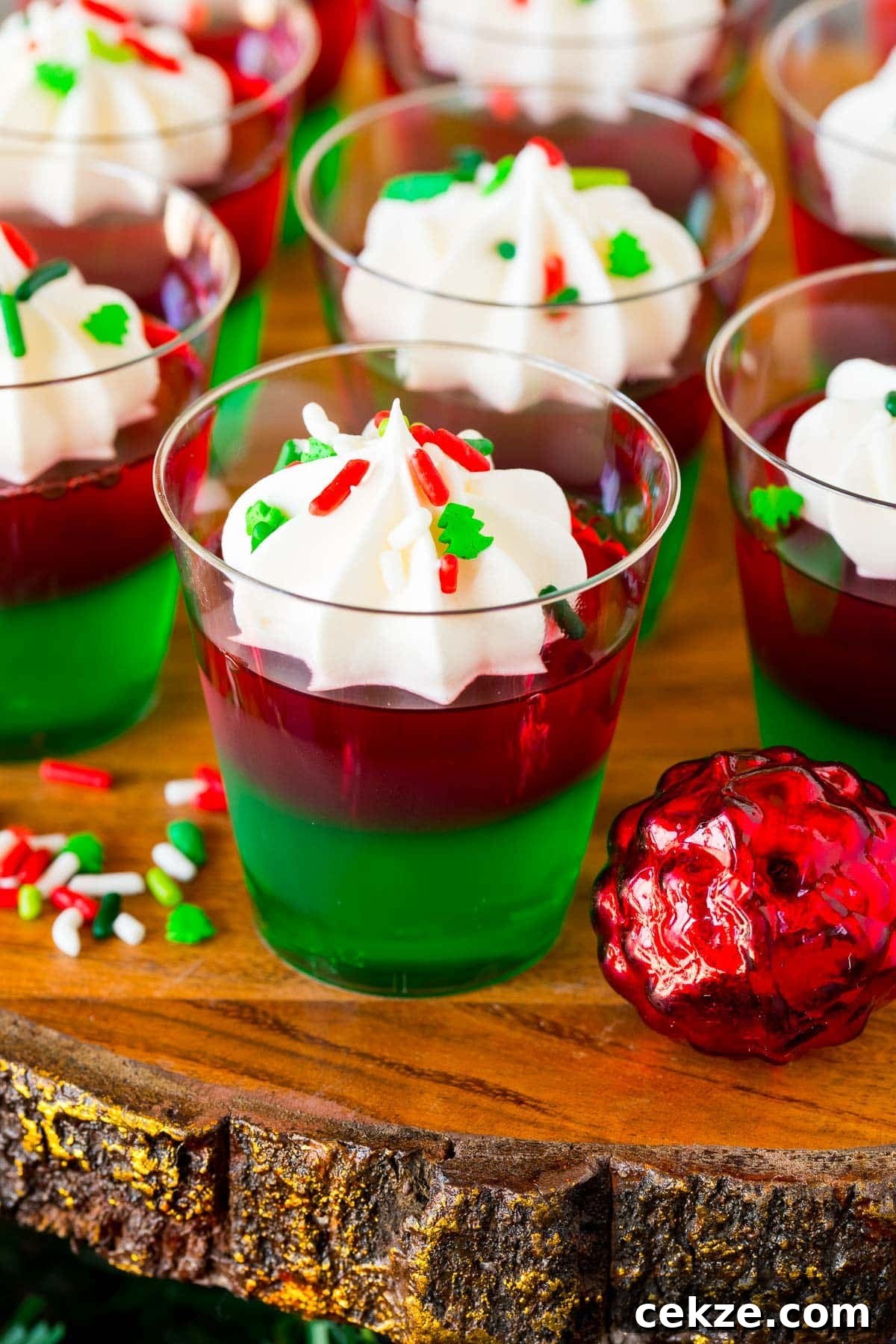 Festive Christmas Jello Shot Recipes for Holiday Parties 2 Christmas Jello shots topped with whipped cream and holiday sprinkles.