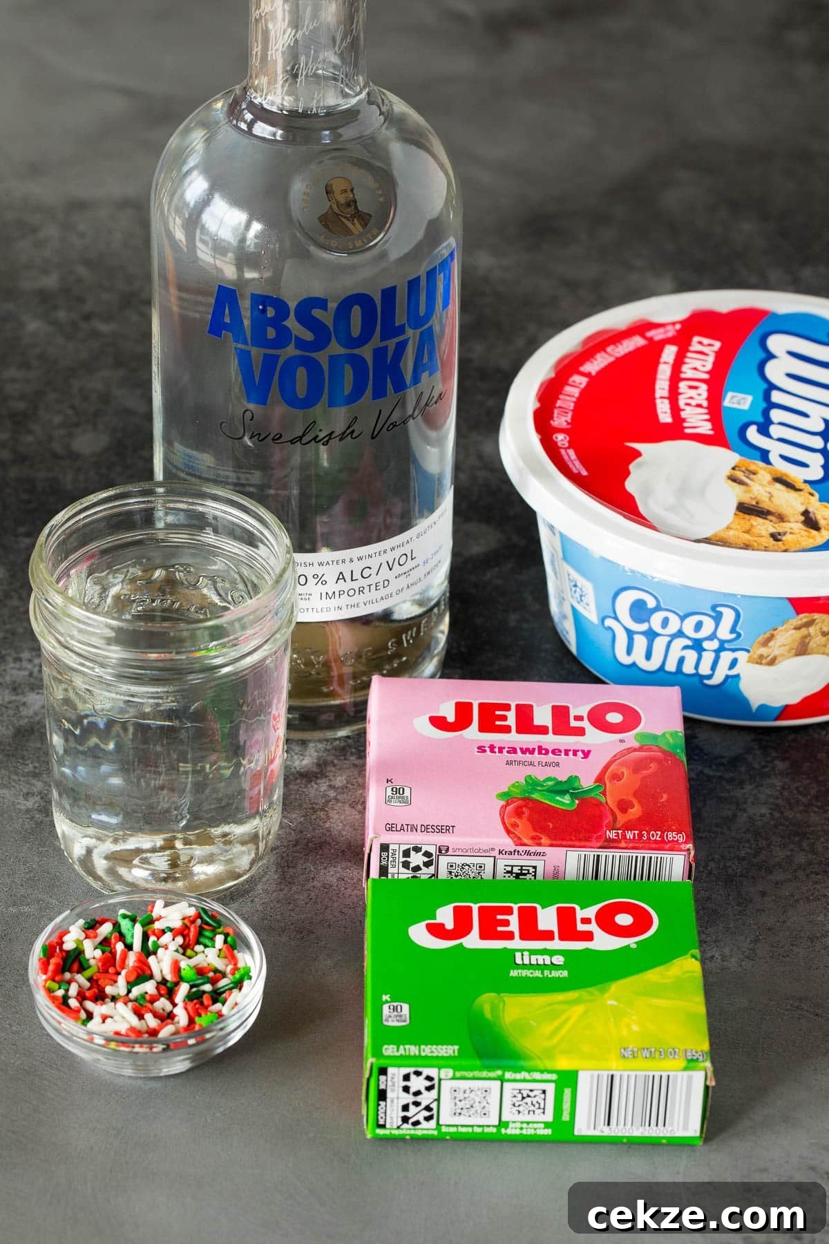 Festive Christmas Jello Shot Recipes for Holiday Parties 3 Ingredients including Jello, water, vodka and sprinkles.