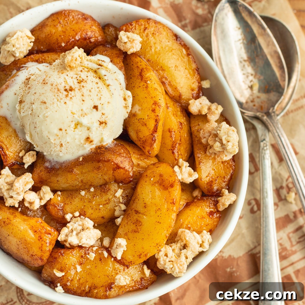 This is a picture of a bowl with cooked apples with ice cream and granola.