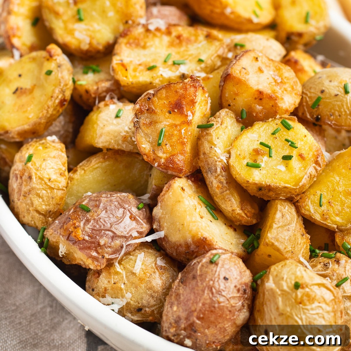 This is a close up square picture of the air fryer parmesan potatoes.