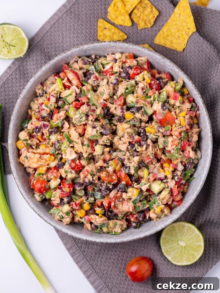 large bowl with mexican tuna salad, gray towel, sliced lime, tortilla chips
