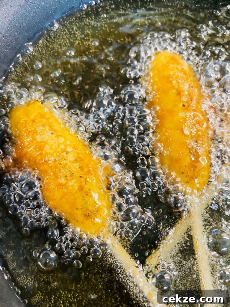 Crispy Sausage Pancake Corn Dogs Recipe 8 breakfast dogs frying in oil
