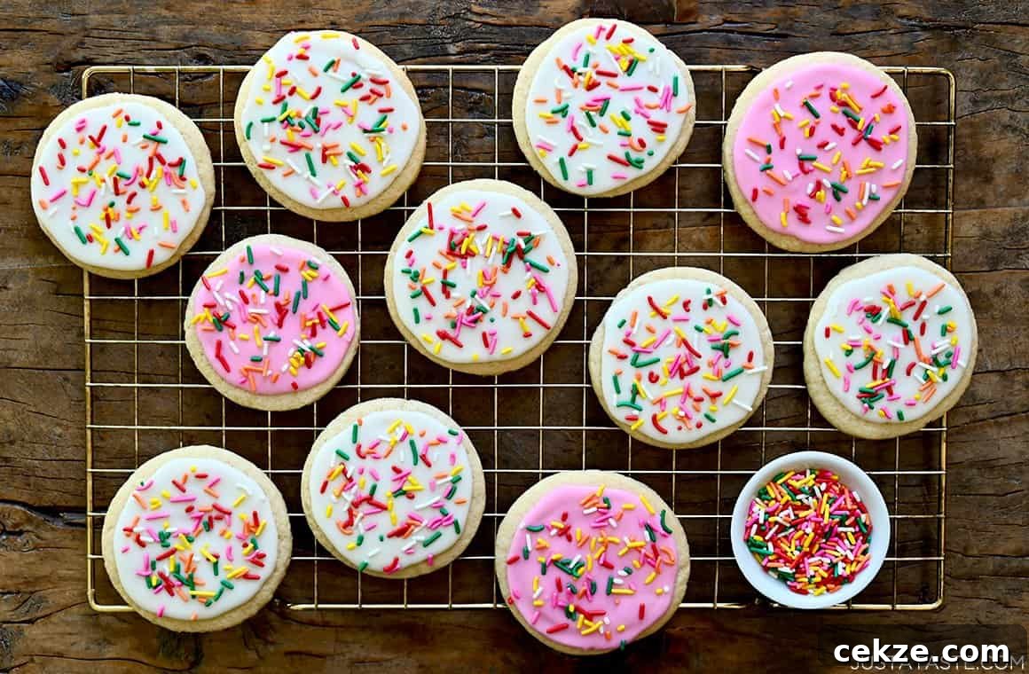 Perfect Sugar Cookie Icing Recipe for Smooth, Glossy Frosting 7 Bakery-style sugar cookies topped with icing and rainbow sprinkles atop a wire rack