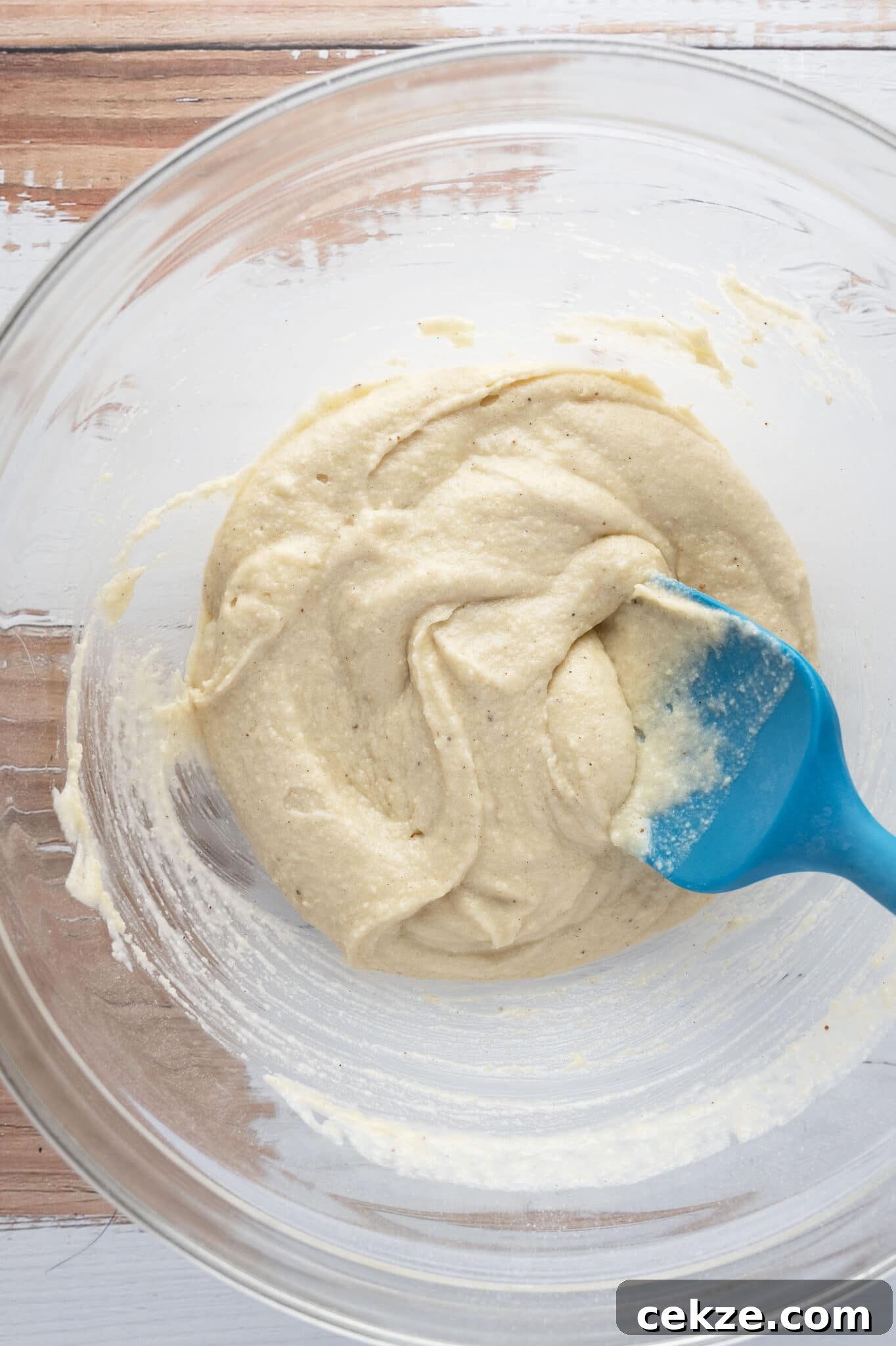 Folding dry ingredients into wet in a clear bowl. 
