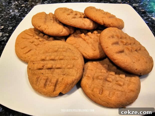 A white plate filled with peanut butter cookies that are ready to be eaten.