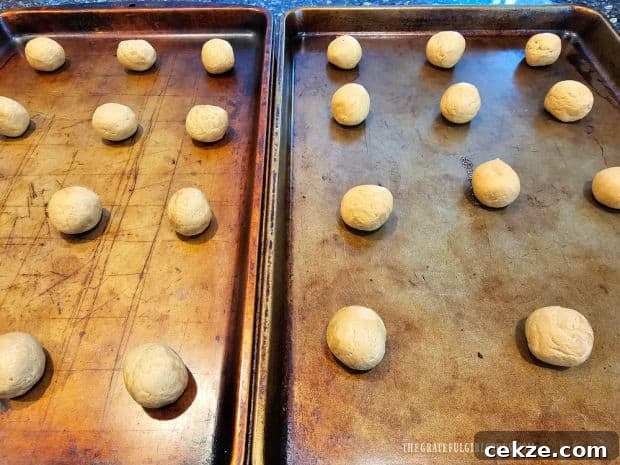 Balls of peanut butter cookie dough on baking sheets 2" apart.