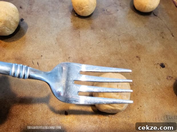 A criss-cross pattern is formed on the cookies using the tines of a fork.