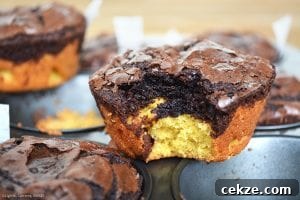 Deep Dish Brookies with a bite out of one on top of a muffin pan. 